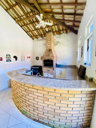a brick bar in a room with a fireplace at Casa Verão Guaratuba - Bertioga in Bertioga