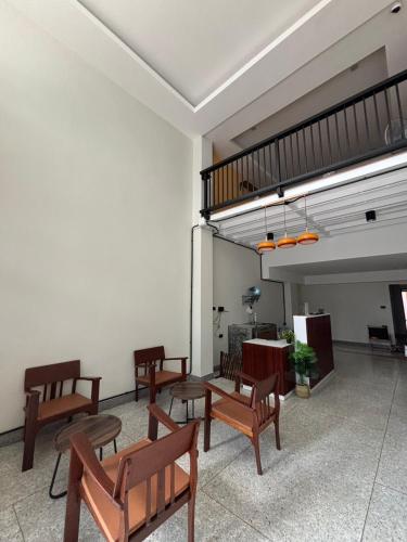 a room with wooden chairs and a loft at Laloon Guesthouse in Hat Yai