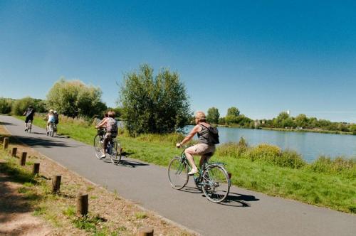 a group of people riding bikes down a road at Gîte La Terrasse du Loir à 2km du Zoo de la Flèche in La Flèche