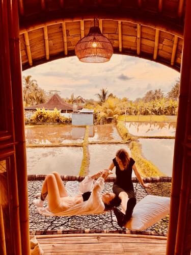 a group of people sitting on beds in a window at Green Lander Ubud in Ubud