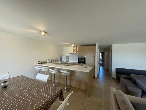 a kitchen and living room with a table and a couch at Appartement Rez de chaussée in La Celle-sous-Gouzon
