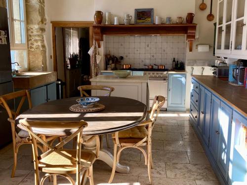 a kitchen with a table and chairs in a kitchen at Maison des Frères Leglise in Miélan