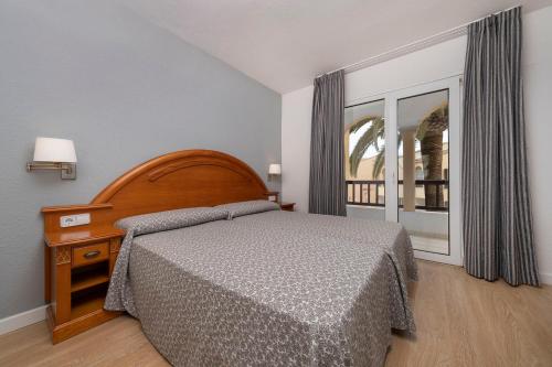 a bedroom with a bed and a window at Apartamentos turísticos Jardines del Plaza in Peñíscola