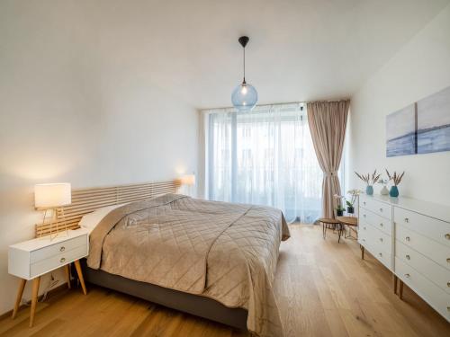 Un dormitorio con una cama y una cómoda y una ventana. en Holesovice Luxury Apartments Free Parking, en Praga