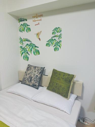 a bedroom with a bed with green leaves on the wall at Shinjuku新宿公園 in Tokyo