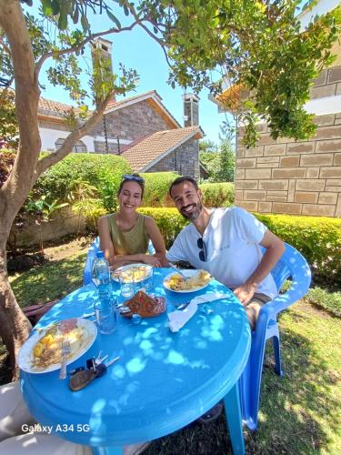 a man and a woman sitting at a blue table at BERNKISH HOMES in Nakuru