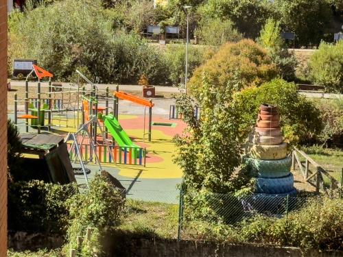 a park with a playground with a colorful play area at Casita con encanto, les gaites in Collanzo