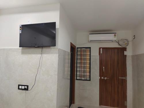 a flat screen tv on the wall of a room at SWASTIK STAY Ac and Non Ac Rooms in Raigīr