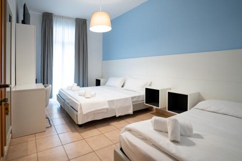 a hotel room with two beds and a large window at Hotel Minerva in Caorle