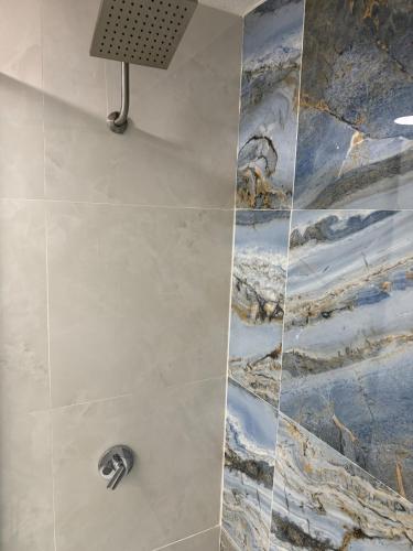 La salle de bains est pourvue d'une douche et d'une peinture murale. dans l'établissement Relaxing Coast - 7, à Arroyo