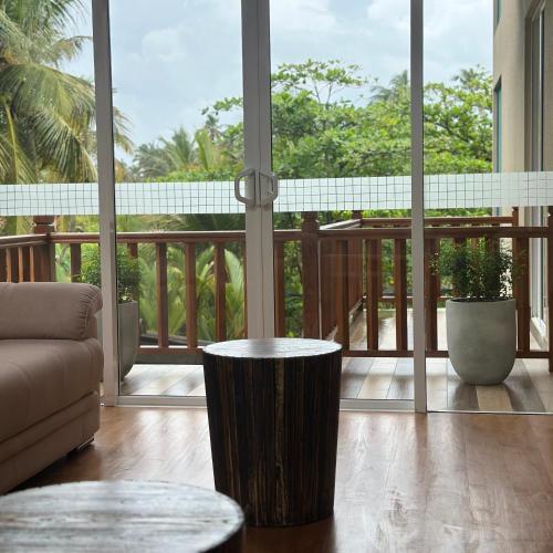 a living room with a view of a balcony with a couch at Kings Landing Unawatuna in Unawatuna