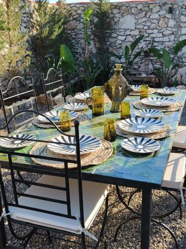 a blue table with plates and a vase on it at Charming Beldi villa with pool in Sidi Kaouki