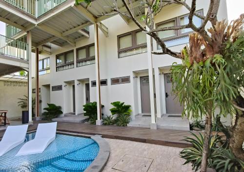 a courtyard with a swimming pool in a building at HŌM Coliving Bali in Kerobokan