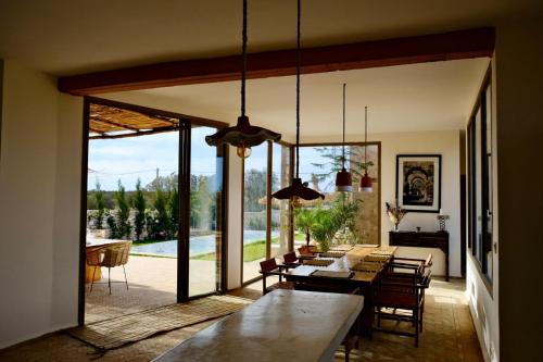 a living room with a table and a large glass door at Charming Beldi villa with pool in Sidi Kaouki
