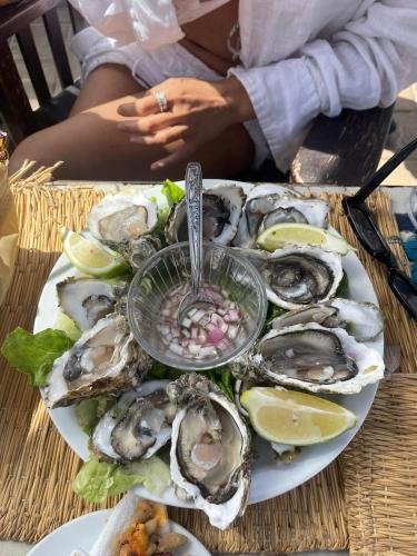 a plate of oysters on a table with a woman at Charming Beldi villa with pool in Sidi Kaouki
