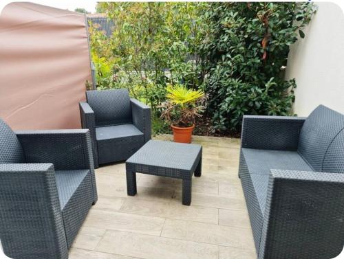 eine Terrasse mit Korbstühlen und einem Tisch in der Unterkunft "Studiocaroline44", 2 studios entre la ville et la mer, parking, cuisine, moins de 15min de l'aéroport in Bouaye