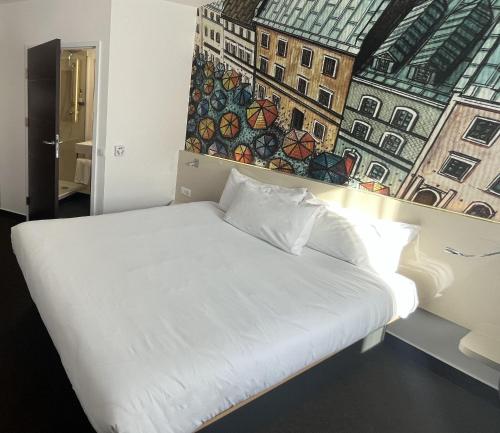 a white bed in a room with a painting on the wall at B&B Hotel Lublin Centrum in Lublin