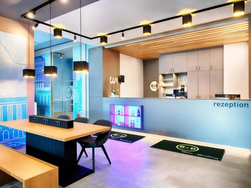 a dining room with a table and a kitchen at B&B Hotel Wien-Meidling in Vienna