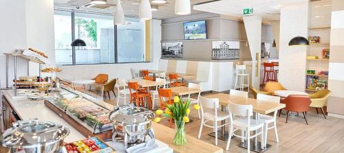 a restaurant with tables and chairs in a room at B&B Hotel Łódź Centrum in Łódź