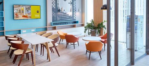 a restaurant with tables and chairs in a room at B&B Hotel Łódź Centrum in Łódź