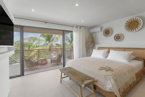 a bedroom with a large bed and a balcony at Villa Coco in Oyster Pond