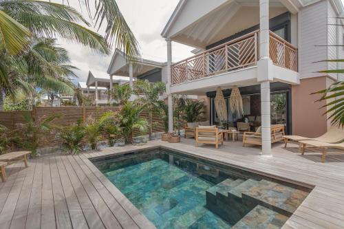 a villa with a swimming pool and a house at Villa Coco in Oyster Pond