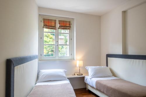 a bedroom with two beds and a window at Resort Antico Verbano in Meina