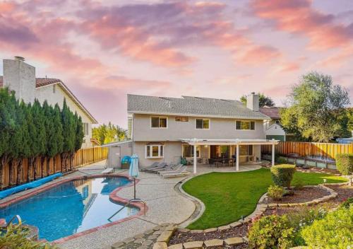 a home with a swimming pool and a fence at @ Marbella Lane - 4BR Cozy home in SJ Pool in San Jose