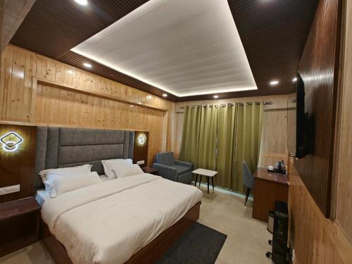a hotel room with a bed and a television at Hotel Yagya in Badrīnāth