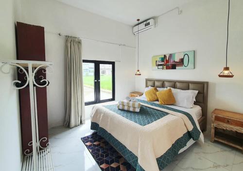 a bedroom with a bed and a window at Villa Cozy Kapal 1BR private pool in Badung