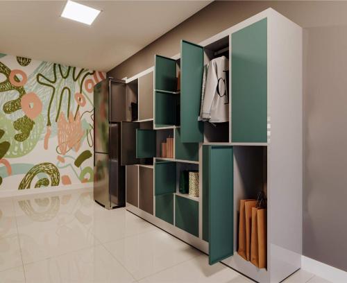 Una habitación con estantes verdes y una pared. en Blend Marista, en Goiânia