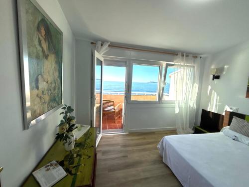 a bedroom with a bed and a view of the ocean at Holibai Albatros, Dúplex al ladito del Mar, con terrazas y piscina, Baiona in Baredo