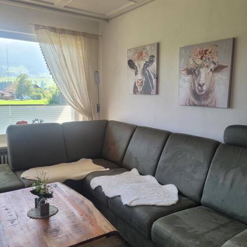 a living room with a leather couch and two paintings at Uschi's Steinröschen in Fischen