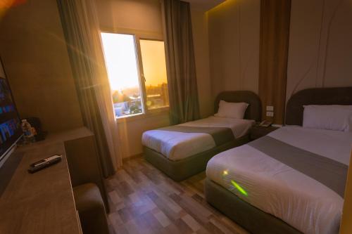 a hotel room with two beds and a television at Elevana Boutique hotel in Cairo