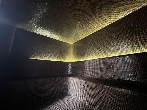 a dark bathroom with a light on the wall at The Beach Tulum Hotel in Tulum