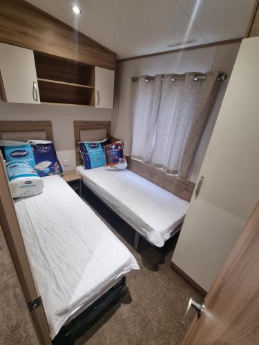 two twin beds in a small room at Coop129 Golden sands holiday park in Kinmel Bay
