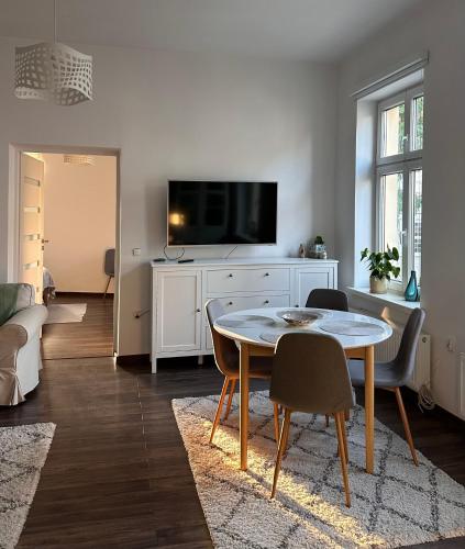 a living room with a table and a tv at Apartament w centrum miasta in Szczytno