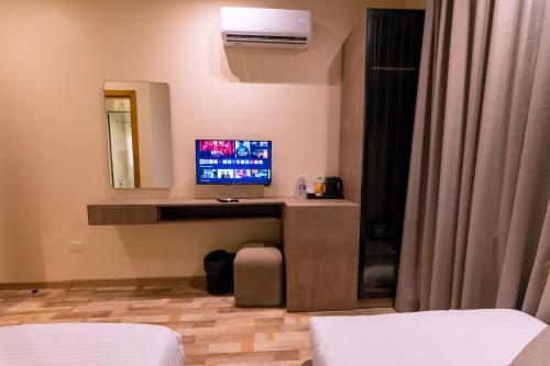 a room with a tv on a desk with a mirror at Elevana Boutique hotel in Cairo