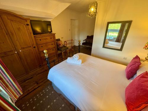 a bedroom with a large white bed and a television at Fairhaven Stay in Betws-y-coed