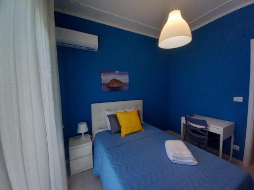 a blue bedroom with a bed with a yellow pillow at Casa Sapio vista mare in Pace Inferiore