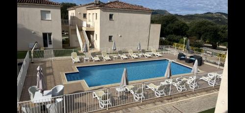 a swimming pool with chairs and a building at Résidence Dicieppo in Ajaccio