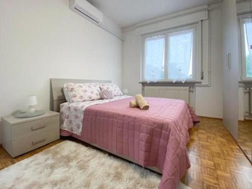 a bedroom with a pink bed with a teddy bear on it at Stay Friuli Pordenone 3 Camere in Pordenone