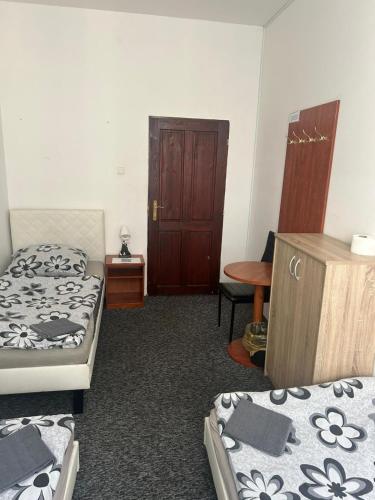 a room with two beds and a wooden door at Rooms v samém centru Ostravy in Ostrava