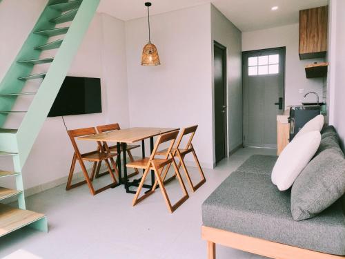 a living room with a table and a couch at HŌM Coliving Bali in Kerobokan