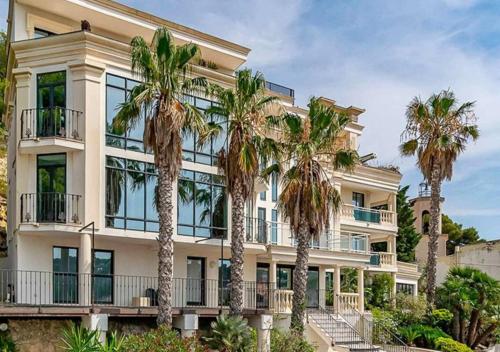 an apartment building with palm trees in front of it at L'Adriana 102 - Clim & wifi - Proximité mer in Carry-le-Rouet