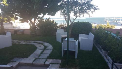 a group of white chairs sitting in the grass at La Dolce Vista - B&B di Charme in Manfredonia