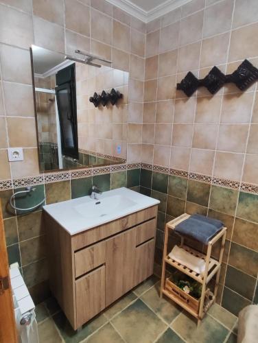 a bathroom with a sink and a mirror and a stool at Amanecer en Playa de LLás in Foz