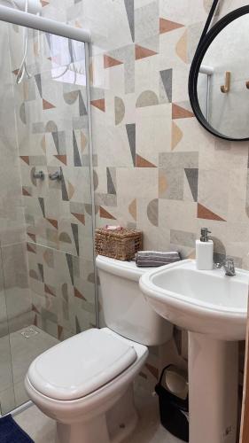 a bathroom with a toilet and a sink at Casa Sete Mares in Guarujá