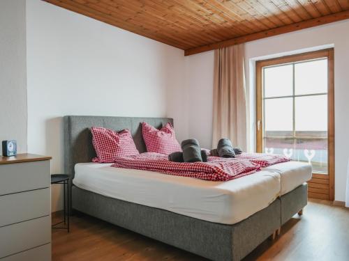 a bedroom with a bed with red pillows and a window at Mountain Residence Riesgut - Sound of Music in Werfen