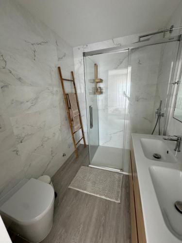 a bathroom with a shower and a toilet and a sink at Imperial Beach House in Vagos